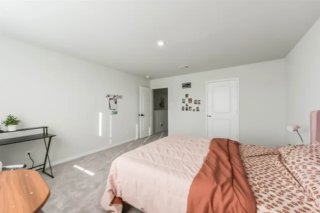 a bedroom with a bed and a dresser with potted plant