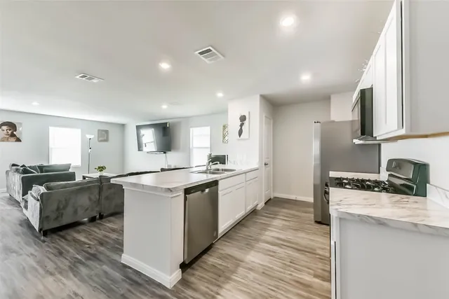 a kitchen with granite countertop a stove top oven and cabinets