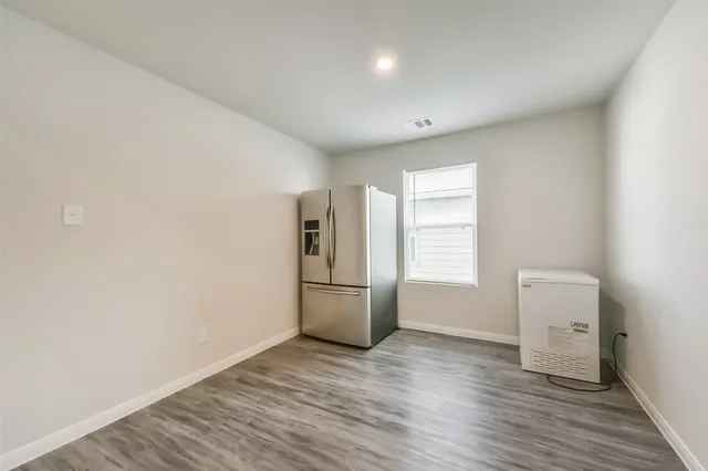 a view of a room with wooden floor and electronic appliances
