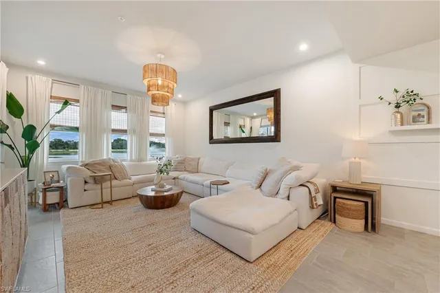 a living room with furniture a large window and a potted plant
