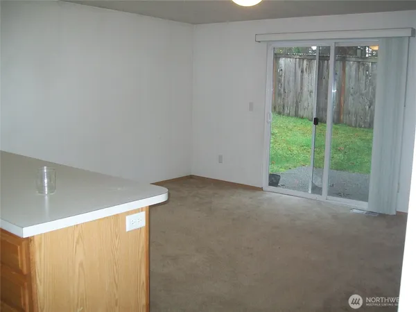 a view of an empty room with wooden floor and a balcony