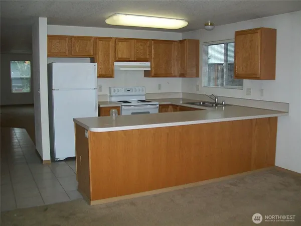 a kitchen with cabinets a refrigerator and a sink
