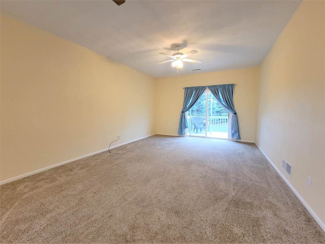 10138 B Monarch Road Roscoe, IL 61073 - Photo 5 of 24 an empty room with windows and chandelier fan