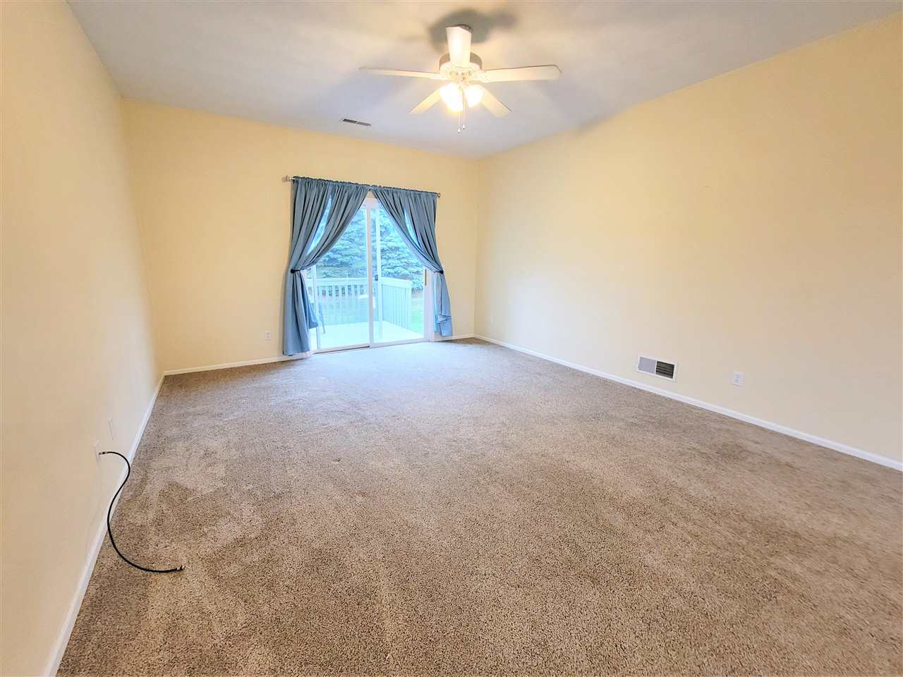 10138 B Monarch Road Roscoe, IL 61073 - Photo 6 of 24 an empty room with windows and fan