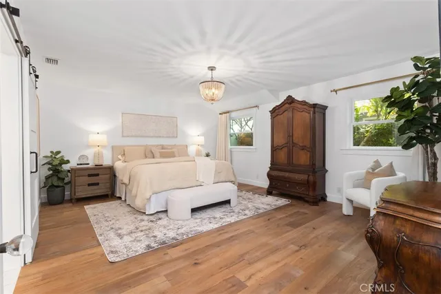 a bedroom with bed and a chandelier