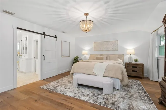 a bedroom with a bed and a chandelier