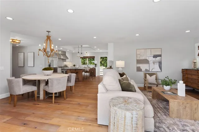 a living room with furniture a table and kitchen view