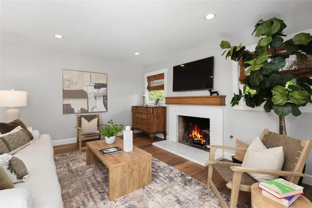 a living room with furniture a fireplace and a flat screen tv