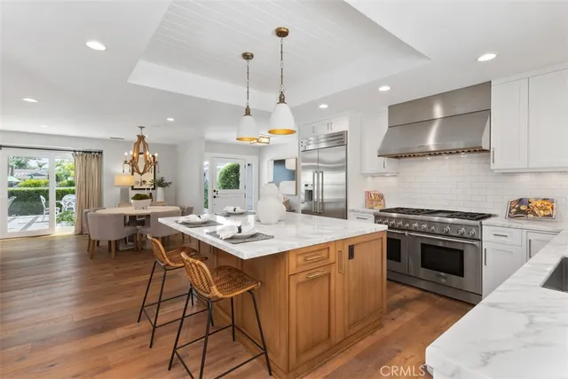 a kitchen with a stove a table and chairs in it