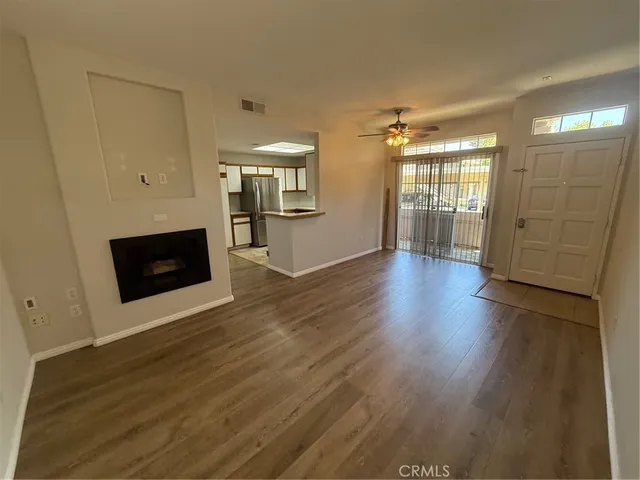 a view of a livingroom with wooden floor and a ceiling fan