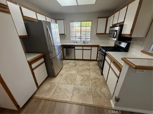 a kitchen with stainless steel appliances a refrigerator sink and wooden cabinets