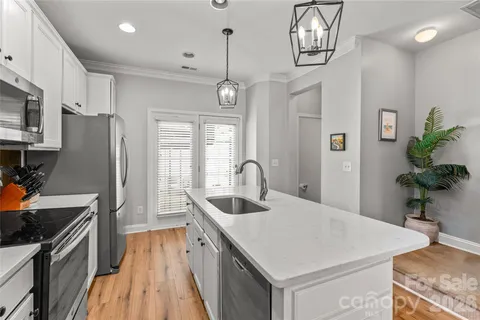 a kitchen with stainless steel appliances granite countertop a sink a stove and a refrigerator