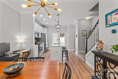 a view of a dining room with furniture a chandelier and wooden floor