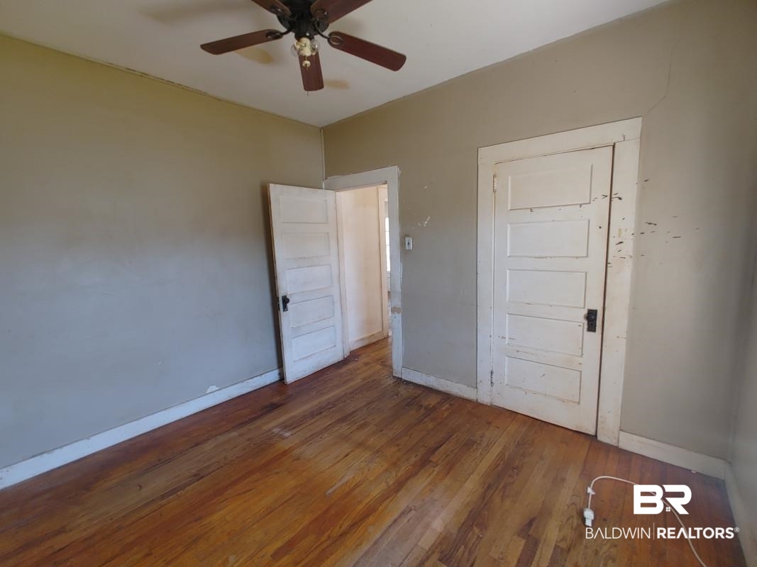 1706 Lomeroy Street Mobile, AL 36604 - Photo 9 of 24 Unfurnished bedroom featuring baseboards, dark wood finished floors, and a ceiling fan