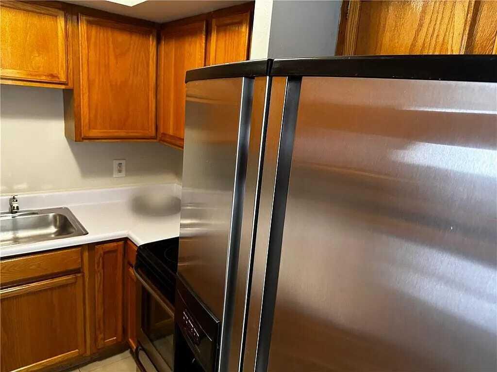 105 South Riverside Drive, Unit 303 Pompano Beach, FL 33062 - Photo 18 of 36 a kitchen with stainless steel appliances granite countertop a refrigerator a sink and dishwasher with wooden floor