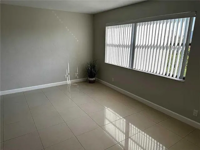 an empty room with wooden floor and a ceiling fan