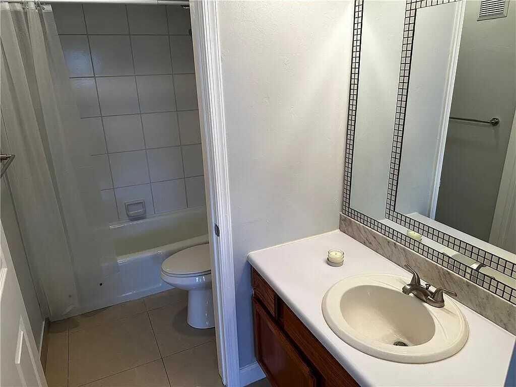 105 South Riverside Drive, Unit 303 Pompano Beach, FL 33062 - Photo 24 of 36 a bathroom with a sink a toilet and a mirror
