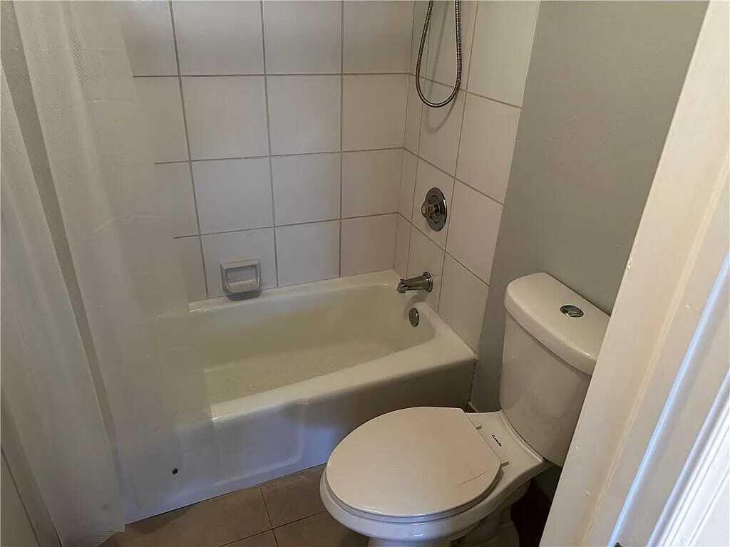 105 South Riverside Drive, Unit 303 Pompano Beach, FL 33062 - Photo 25 of 36 a white toilet sitting next to a bath tub