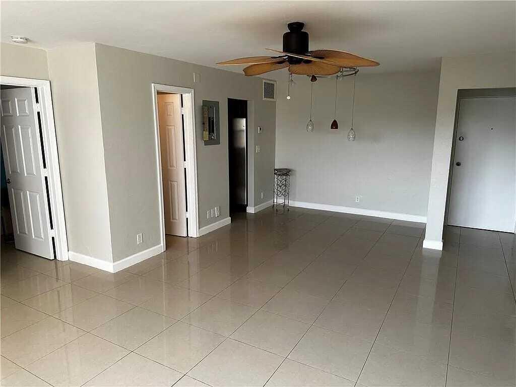 105 South Riverside Drive, Unit 303 Pompano Beach, FL 33062 - Photo 31 of 36 an empty room with wooden floor and a ceiling fan