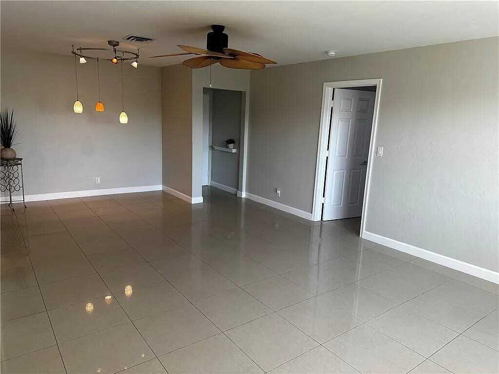 105 South Riverside Drive, Unit 303 Pompano Beach, FL 33062 - Photo 36 of 36 an empty room with wooden floor and windows