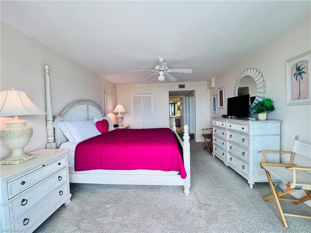 25 Bluebill Avenue, Unit 1002 Naples, FL 34108 - Photo 15 of 34 a bedroom with furniture and flat screen tv