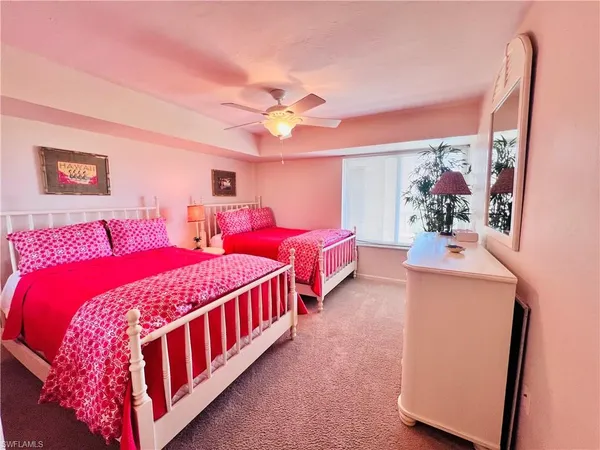 a bedroom with three beds and a chandelier