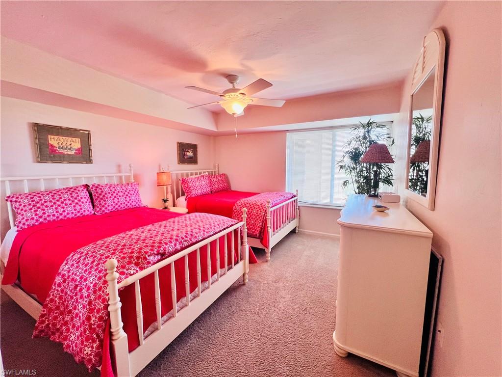 25 Bluebill Avenue, Unit 1002 Naples, FL 34108 - Photo 18 of 34 a bedroom with three beds and a chandelier