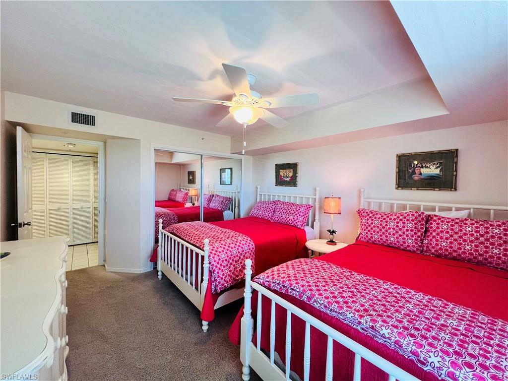 25 Bluebill Avenue, Unit 1002 Naples, FL 34108 - Photo 19 of 34 a bedroom with three beds and a chandelier