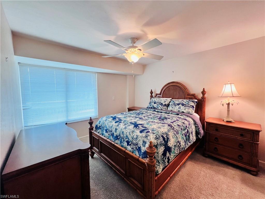 25 Bluebill Avenue, Unit 1002 Naples, FL 34108 - Photo 20 of 34 a bedroom with a bed and a chandelier