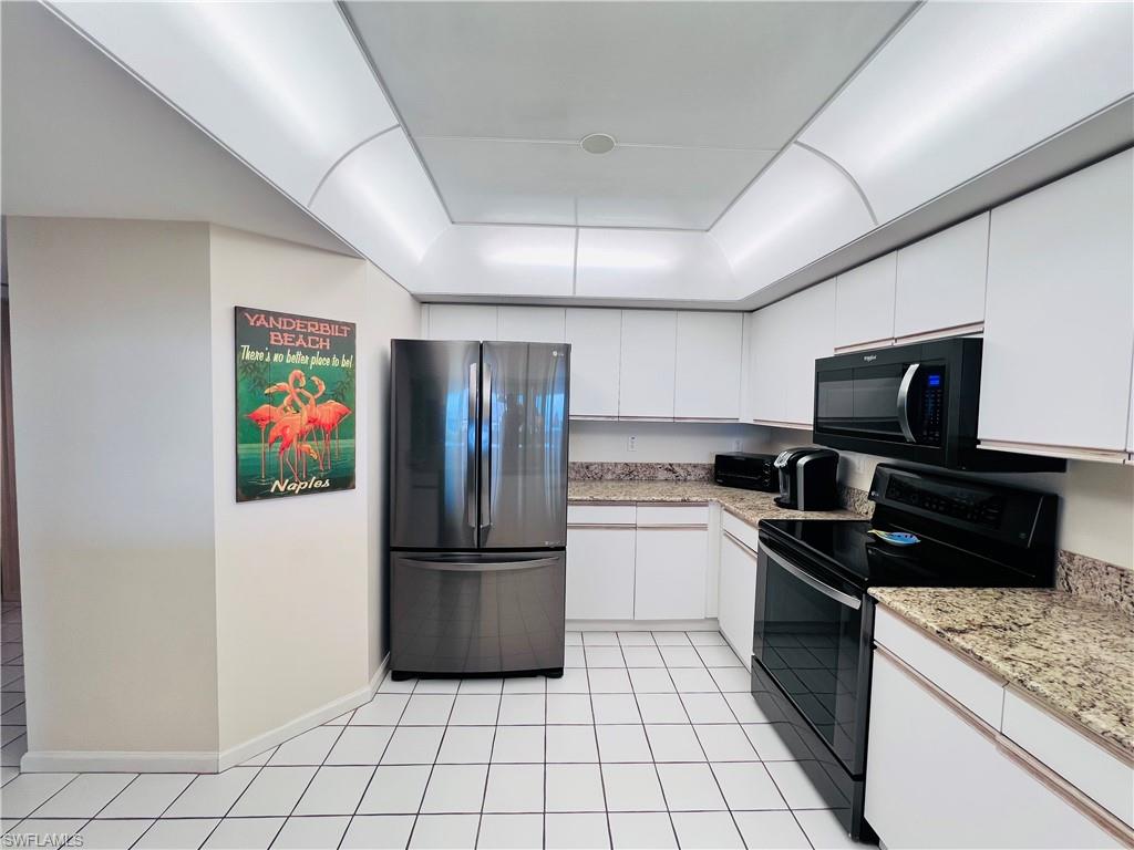 25 Bluebill Avenue, Unit 1002 Naples, FL 34108 - Photo 4 of 34 a kitchen with granite countertop a refrigerator and a stove top oven