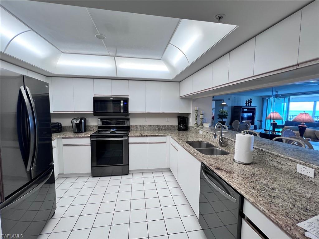25 Bluebill Avenue, Unit 1002 Naples, FL 34108 - Photo 5 of 34 a kitchen with a sink a counter top space cabinets and stainless steel appliances