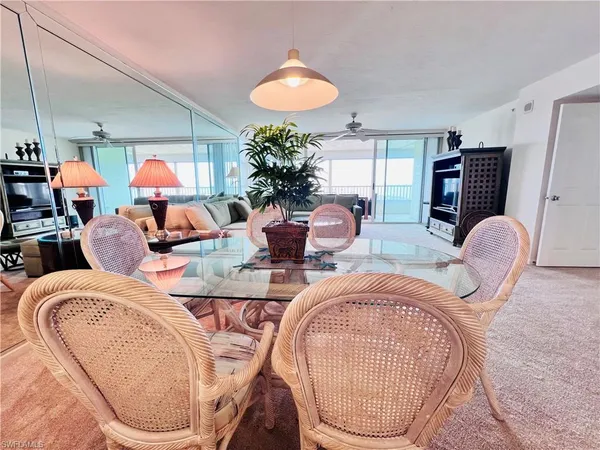 a living room with furniture a chandelier and a mirror