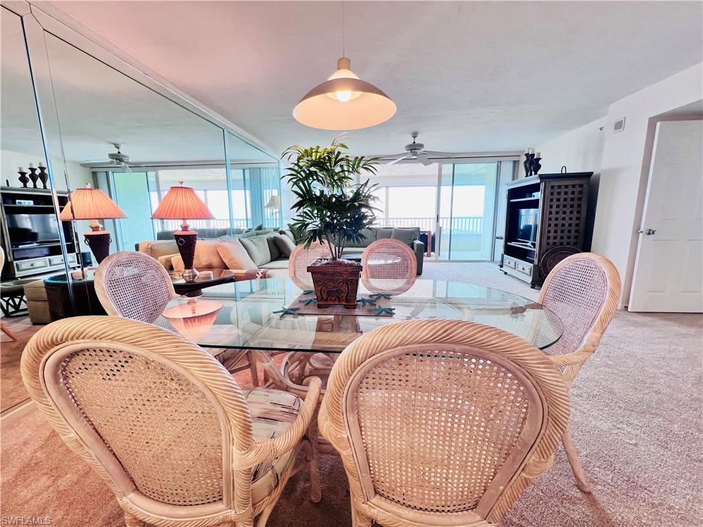 25 Bluebill Avenue, Unit 1002 Naples, FL 34108 - Photo 9 of 34 a living room with furniture a chandelier and a mirror
