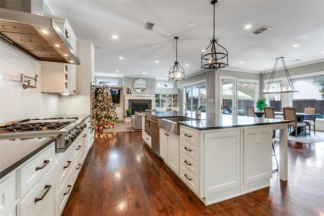 a kitchen with stainless steel appliances granite countertop a lot of counter space and wooden floors