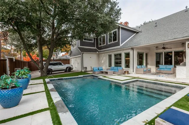 a view of a house with swimming pool and sitting area