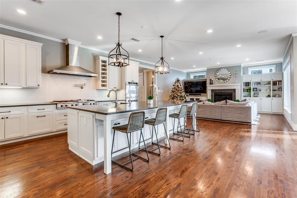 413 Ridge Crest Drive Richardson, TX 75080 - Photo 9 of 34 a open kitchen with stainless steel appliances granite countertop a stove top oven a sink dishwasher and a dining table with wooden floor