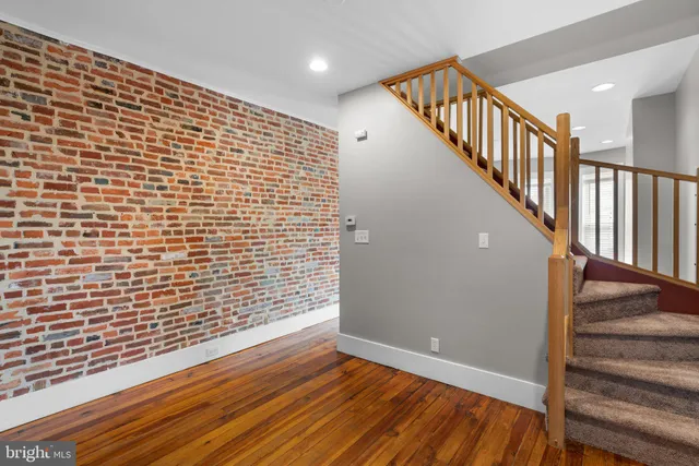 a view of a hallway with wooden floor and staircase