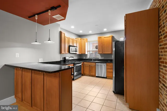 a kitchen with stainless steel appliances granite countertop a sink a counter space and cabinets