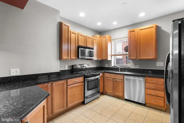 a kitchen with stainless steel appliances granite countertop wooden cabinets a sink and dishwasher