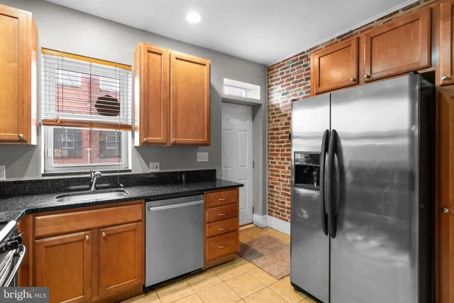 a kitchen with stainless steel appliances granite countertop a refrigerator and a sink