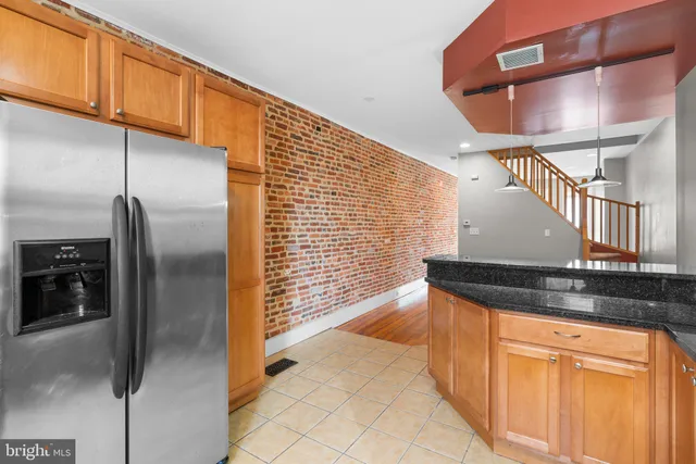 a kitchen with stainless steel appliances granite countertop a sink a refrigerator and cabinets