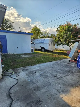 a view of a house with backyard and a tree