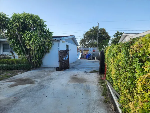 a view of a house with a yard and potted plants