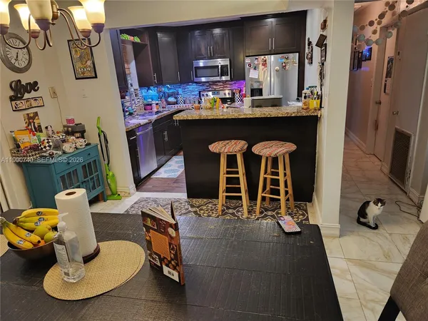 a dining room with furniture and kitchen view