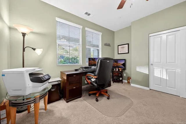 a view of a workspace with furniture and a window