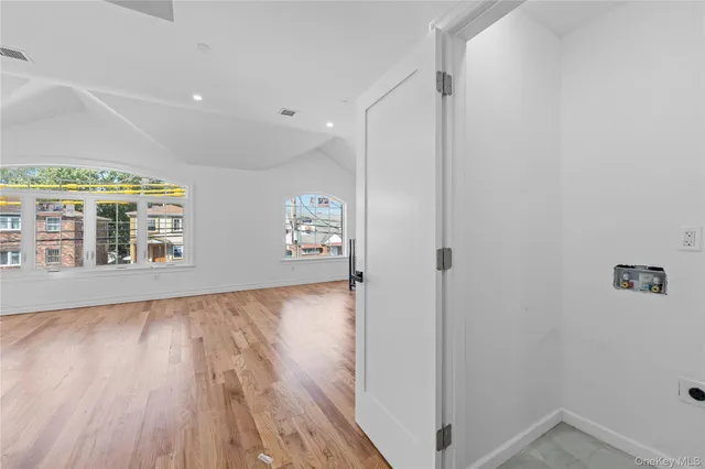 a kitchen with kitchen island wooden floors appliances and cabinets