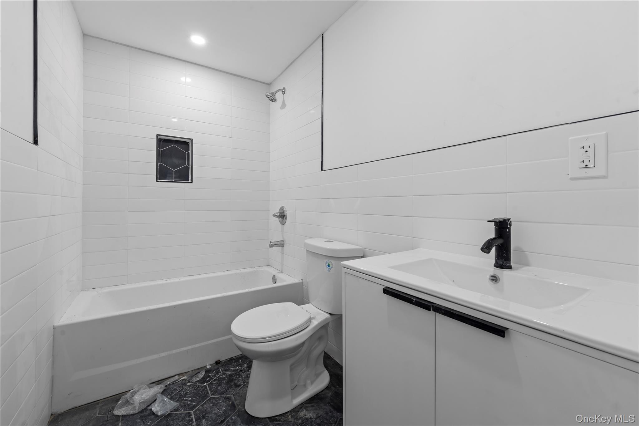 258-10 147th Road Queens, NY 11422 - Photo 23 of 26 Bathroom with vanity, shower combination, tile walls, and recessed lighting