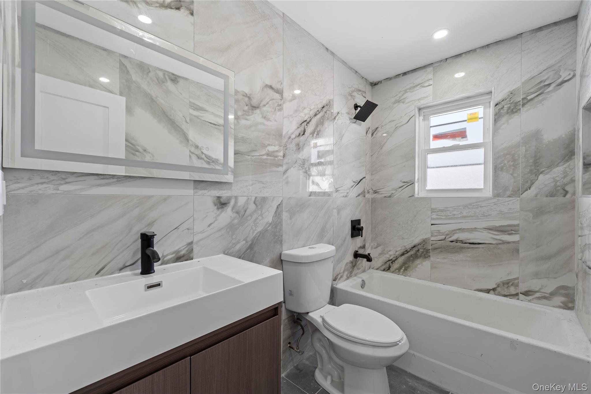 258-10 147th Road Queens, NY 11422 - Photo 6 of 26 Full bathroom with tile walls, shower / bathtub combination, and vanity