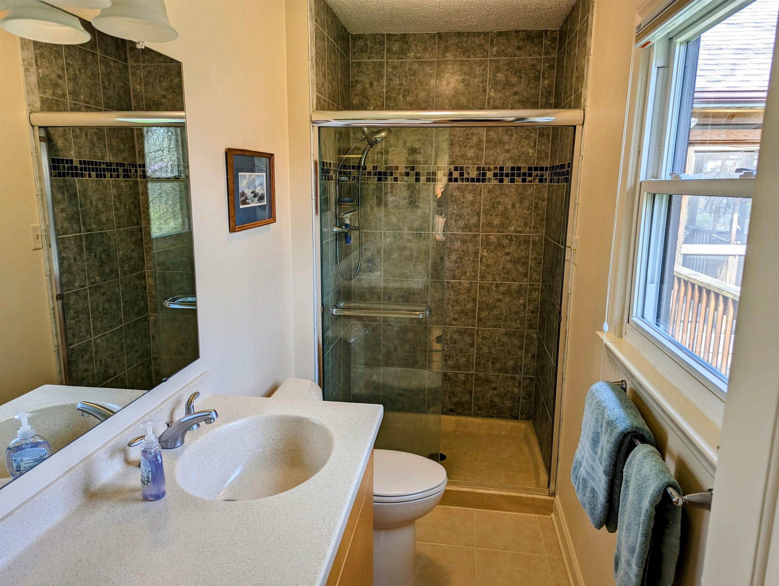4503 Malvern Road Durham, NC 27707 - Photo 23 of 37 Ensuite bath has been renovated with ceramic tile shower, Hi-Macs solid surface counter top, comfort height vanity and comfort height toilet. Owners' bathroom