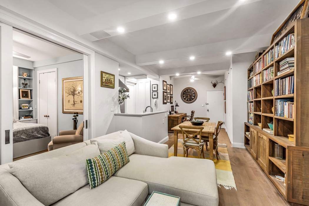 64 East 94th Street, Unit 1G Manhattan, NY 10128 - Photo 5 of 11 a living room with fireplace furniture and a book shelf